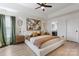 Stylish main bedroom featuring a tray ceiling, modern decor, and a glimpse into the adjoining bathroom, creating a luxurious retreat at 14024 Alley Son St, Huntersville, NC 28078