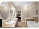 Bright bathroom with double sinks, tiled floors, and a soaking tub with tile accents at 14124 Hiwassee Rd, Huntersville, NC 28078