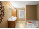 Bright bathroom featuring a double sink vanity, and a bathtub with a decorative orange towel at 14124 Hiwassee Rd, Huntersville, NC 28078