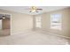 Bright bedroom with two windows, neutral carpet, ceiling fan, and minimal staging for a spacious feel at 14124 Hiwassee Rd, Huntersville, NC 28078