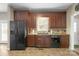 Traditional kitchen with dark wood cabinetry, black appliances, and a window over the sink at 14124 Hiwassee Rd, Huntersville, NC 28078