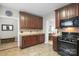 Kitchen showcases dark wood cabinets, granite countertops, and black appliances with a tile backsplash at 14124 Hiwassee Rd, Huntersville, NC 28078