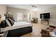 Virtually Staged bright main bedroom with hardwood floors, natural light, sitting area, and ceiling fan at 14124 Hiwassee Rd, Huntersville, NC 28078