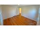 Bedroom with hardwood floors, a window, and an open doorway to another room at 2020 Parkdale Ave, Gastonia, NC 28052