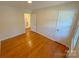 A cozy bedroom shows hardwood floors and a doorway that connects to another room at 2020 Parkdale Ave, Gastonia, NC 28052
