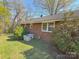 Brick home exterior with updated AC unit surrounded by green grass and mature shrubs at 2020 Parkdale Ave, Gastonia, NC 28052