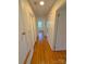 A hallway showcases hardwood floors, multiple doors, and natural light from a distance at 2020 Parkdale Ave, Gastonia, NC 28052