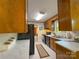 Kitchen featuring wood cabinets, black appliances, and bright countertops with view to hallway at 2020 Parkdale Ave, Gastonia, NC 28052