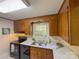 Cozy kitchen featuring wood cabinets, black appliances and bright countertops with a window view at 2020 Parkdale Ave, Gastonia, NC 28052