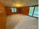Spacious living room with wood paneling and sliding glass door at 2020 Parkdale Ave, Gastonia, NC 28052