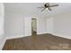 Bedroom featuring wood-look flooring, white trim, a ceiling fan, and open closet door at 209 N Yadkin Ave, Spencer, NC 28159