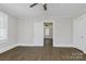 Bedroom with hardwood-style floors, neutral walls, and a view into an adjoining room at 209 N Yadkin Ave, Spencer, NC 28159