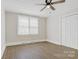 Well-lit bedroom featuring a ceiling fan, double closet, and natural light from the window at 209 N Yadkin Ave, Spencer, NC 28159