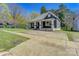 Exterior view of a quaint home showcasing a covered front porch and ample driveway space at 209 N Yadkin Ave, Spencer, NC 28159