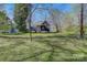 Quaint cottage-style home with lush green lawn and mature trees at 209 N Yadkin Ave, Spencer, NC 28159