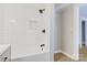 Beautifully tiled shower and tub with black fixtures, white subway tile, and recessed shelf at 209 N Yadkin Ave, Spencer, NC 28159