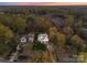 Aerial view of a beautiful home nestled amongst lush, mature trees at sunset at 209 Sardis Ln, Charlotte, NC 28270