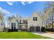 Stunning two-story home with modern glass panel garage doors, manicured lawn, and mature trees at 209 Sardis Ln, Charlotte, NC 28270