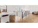 Bright upstairs hallway with modern railing, hardwood floors, and a desk/study area at 209 Sardis Ln, Charlotte, NC 28270