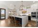 Spacious kitchen with white cabinets, a large island with bar seating, and modern pendant lighting at 209 Sardis Ln, Charlotte, NC 28270