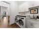 Efficient laundry room with modern washer and dryer, built-in cabinets and sink at 209 Sardis Ln, Charlotte, NC 28270
