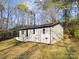 This exterior view features a freshly painted white brick exterior, mature trees, and a well-maintained lawn at 2120 Green Oak Dr, Shelby, NC 28152