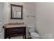 Well-lit half bathroom with a granite vanity and wood flooring at 21721 Shoveller Ct, Cornelius, NC 28031