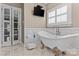 Charming bathroom with a soaking tub, modern tiling, and natural lighting at 21721 Shoveller Ct, Cornelius, NC 28031