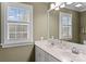 Bathroom with double sink vanity, mirror, and window with natural light at 21721 Shoveller Ct, Cornelius, NC 28031