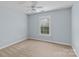 This cozy bedroom offers soft carpet, a ceiling fan, and natural light from the window at 21721 Shoveller Ct, Cornelius, NC 28031