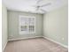 Light-filled bedroom featuring neutral walls, carpet, and a window overlooking the outdoors at 21721 Shoveller Ct, Cornelius, NC 28031