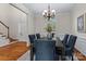 Elegant dining room with a wooden table, six upholstered chairs, wainscotting, and decorative chandelier at 21721 Shoveller Ct, Cornelius, NC 28031