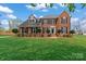 Charming two-story brick home with a manicured lawn, mature landscaping, and black shutters on a sunny day at 21721 Shoveller Ct, Cornelius, NC 28031