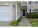 Two-story home featuring an attached two-car garage with front door with nice bushes at 2919 Bridgeville Ln, Charlotte, NC 28262