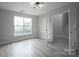 Living room with a large window and light fixture, new wood flooring, and access to other rooms at 2919 Bridgeville Ln, Charlotte, NC 28262