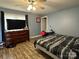 This bedroom features a ceiling fan, mounted television and wood-look floors at 300 S Oakland Ave, Statesville, NC 28677