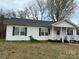 Charming single-story home featuring vinyl siding, a covered porch, and manicured landscaping at 300 S Oakland Ave, Statesville, NC 28677