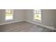 Bright bedroom featuring neutral walls, wood-look flooring, and natural light from two windows at 333 City Ave, Lancaster, SC 29720