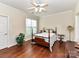 Comfortable bedroom featuring a four-poster bed, hardwood floors, ceiling fan, and natural light at 3721 Oak View Ct, Matthews, NC 28105