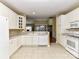Bright kitchen boasts white cabinetry, tile floors, and a breakfast bar overlooking the dining area at 3721 Oak View Ct, Matthews, NC 28105