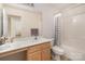 Bathroom featuring a white vanity, toilet, and a shower with a striped curtain, offering a clean and functional space at 4039 Holly Villa Cir, Indian Trail, NC 28079