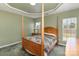 Green bedroom featuring a four-poster bed, complemented by a tray ceiling and natural light from the window at 4039 Holly Villa Cir, Indian Trail, NC 28079