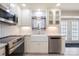 Modern kitchen with white farmhouse sink, stainless steel dishwasher, granite countertops and natural lighting at 4487 Catawba Burris Rd, Denver, NC 28037