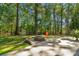 Backyard view showcasing a shed, firepit area, mature trees, and concrete patio at 4586 Chanel Ct, Concord, NC 28025