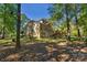 Rear view of a brick house with a large deck and a spacious, tree-filled backyard at 4586 Chanel Ct, Concord, NC 28025