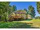 Expansive backyard featuring a large brick home with a raised wooden deck and mature trees at 4586 Chanel Ct, Concord, NC 28025