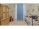 Cozy bedroom showcases a charming wardrobe and a daybed beneath bright windows with blue-and-white curtains at 4586 Chanel Ct, Concord, NC 28025