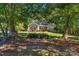 Stately brick home nestled among mature trees with a manicured front lawn at 4586 Chanel Ct, Concord, NC 28025