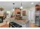 Kitchen island with granite countertop, sink, seating, and open view to the living room fireplace at 4586 Chanel Ct, Concord, NC 28025