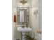 Powder room featuring a pedestal sink, decorative mirror, and modern fixtures at 4586 Chanel Ct, Concord, NC 28025